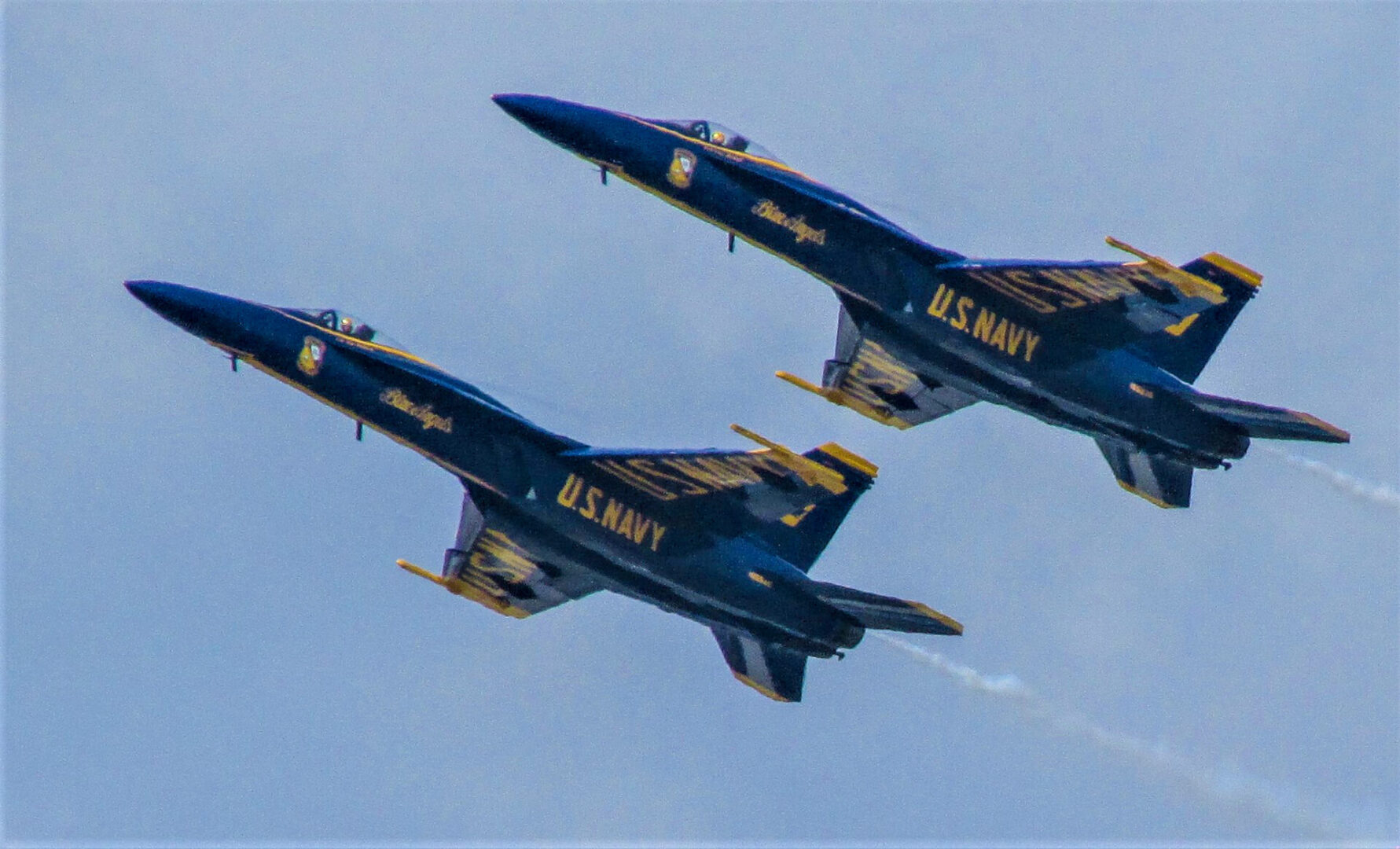 Two blue angels jets flying in formation.