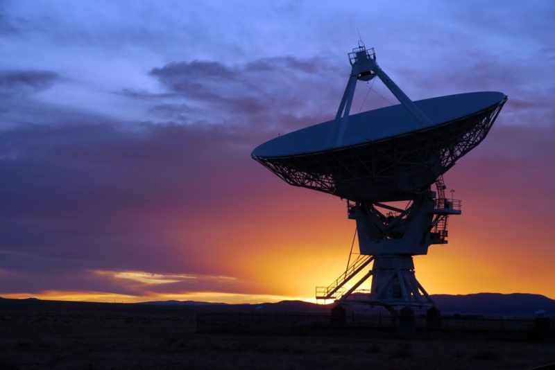 A large satellite dish sitting on top of a field.