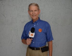 A man in blue shirt holding a microphone.