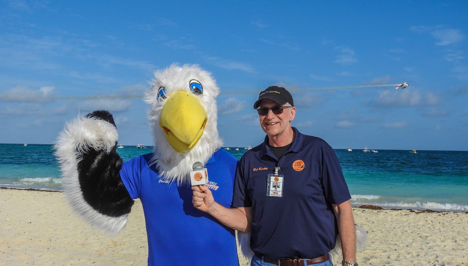 A man standing next to an eagle on the beach