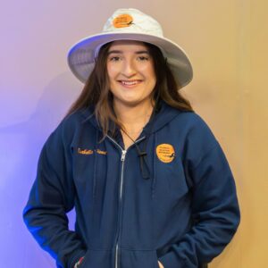Young woman wearing a blue jacket, hat.