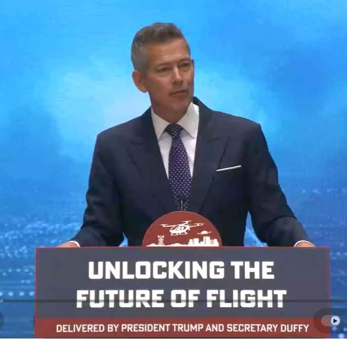 Man speaking at aviation-themed event podium.